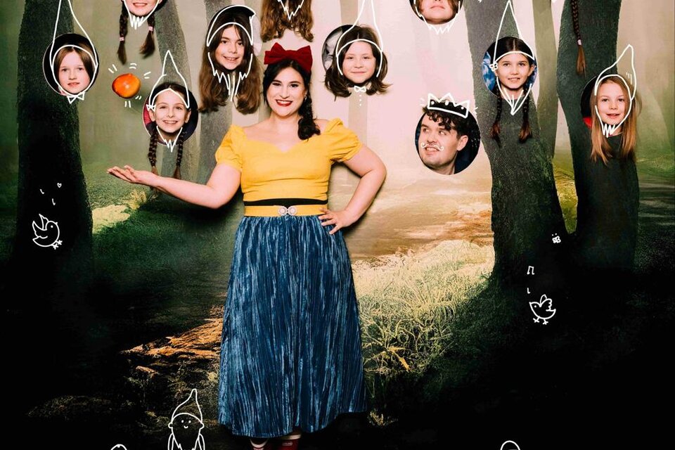 Eine Person steht in einem Wald mit vielen bunten Köpfen, die über ihr schweben. Die Szenografie hat einen märchenhaften Charakter mit Zeichnungen von Zwergen und Tieren. | © Oper Graz