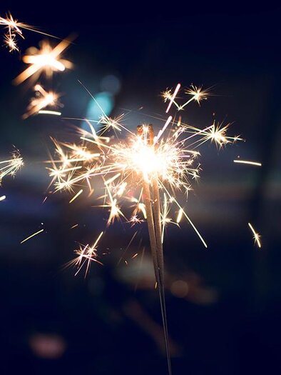 A sparkling firework lights up the darkness. Glittering sparks radiate around it, creating a festive atmosphere. | © freepik