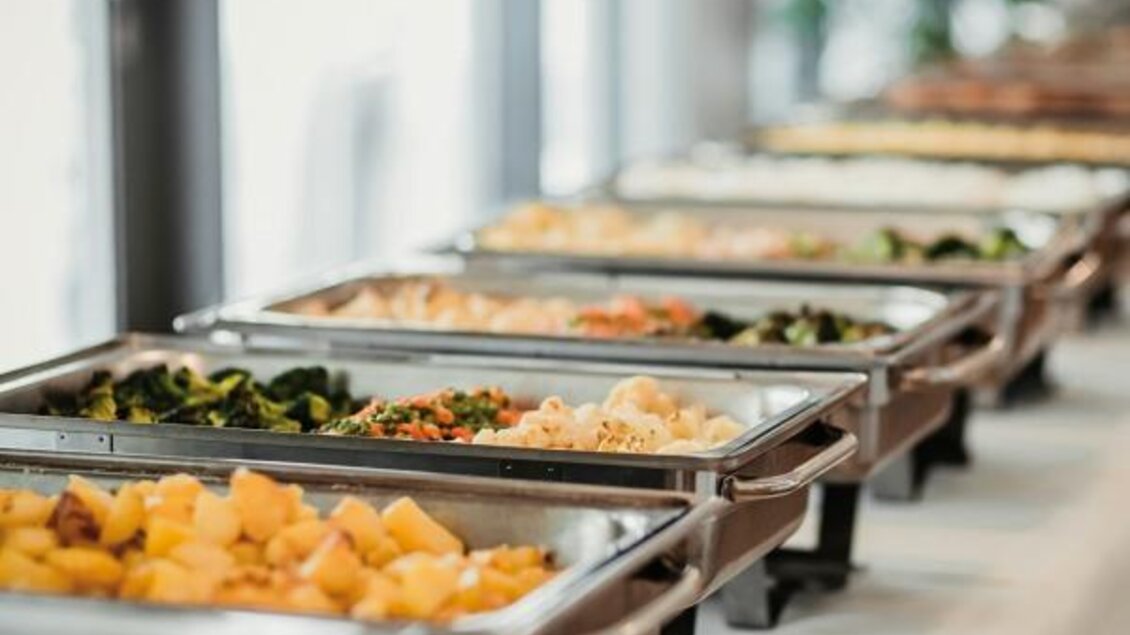 Ein Buffet mit verschiedenen Gerichten in warmen Halterungen. Die Auswahl umfasst Gemüse, Kartoffeln und andere Speisen. | © Kinelly