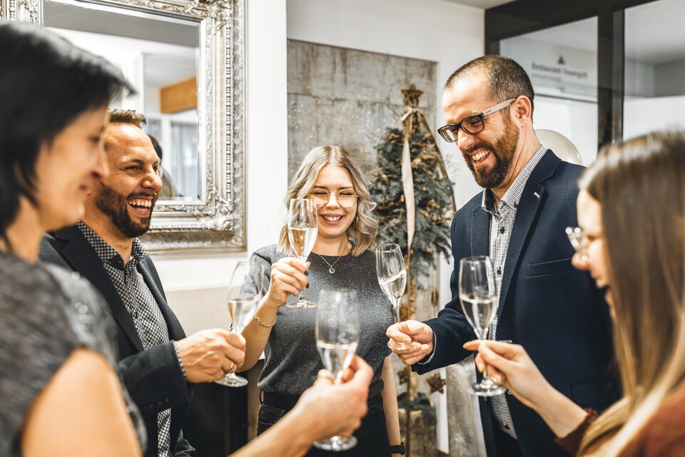 Eine Gruppe von fünf Personen feiert gemeinsam mit Sektgläsern. Sie lächeln und stoßen auf einen besonderen Moment an. | © Vulkanlandhotel Legenstein