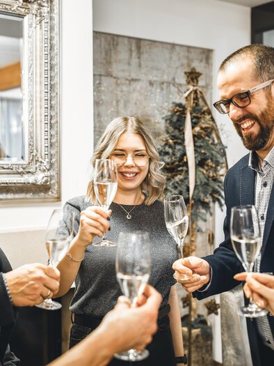 Eine Gruppe von fünf Personen feiert gemeinsam mit Sektgläsern. Sie lächeln und stoßen auf einen besonderen Moment an. | © Vulkanlandhotel Legenstein