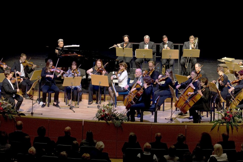 Ein Orchester spielt, während die Musiker ihre Violinen halten. Die Atmosphäre ist konzentriert und musikalisch. | © Walter Schindler