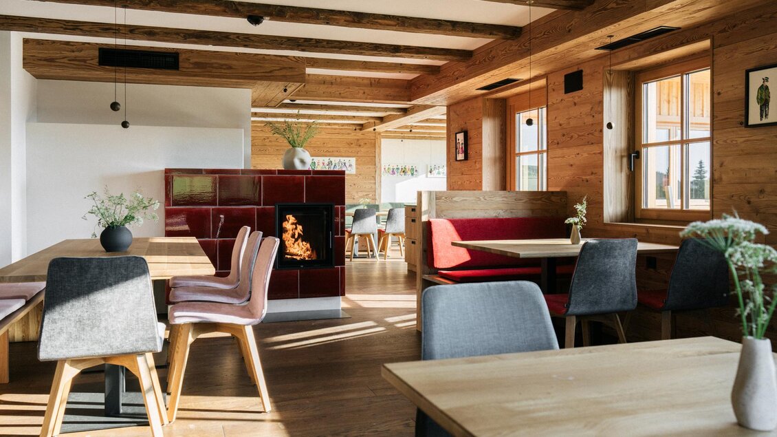 Ein modernes Restaurantinterieur mit Holzbalken, gemütlichen Tischen und Stühlen. Das Licht strömt durch die Fenster und schafft eine einladende Atmosphäre. | © Weizerhütte