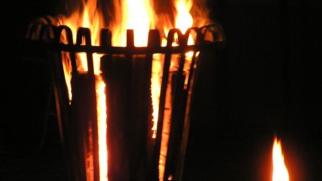 Ein Lagerfeuer in einem Korb strahlt warmes Licht aus. Daneben brennt eine kleine Flamme. | © Lederer