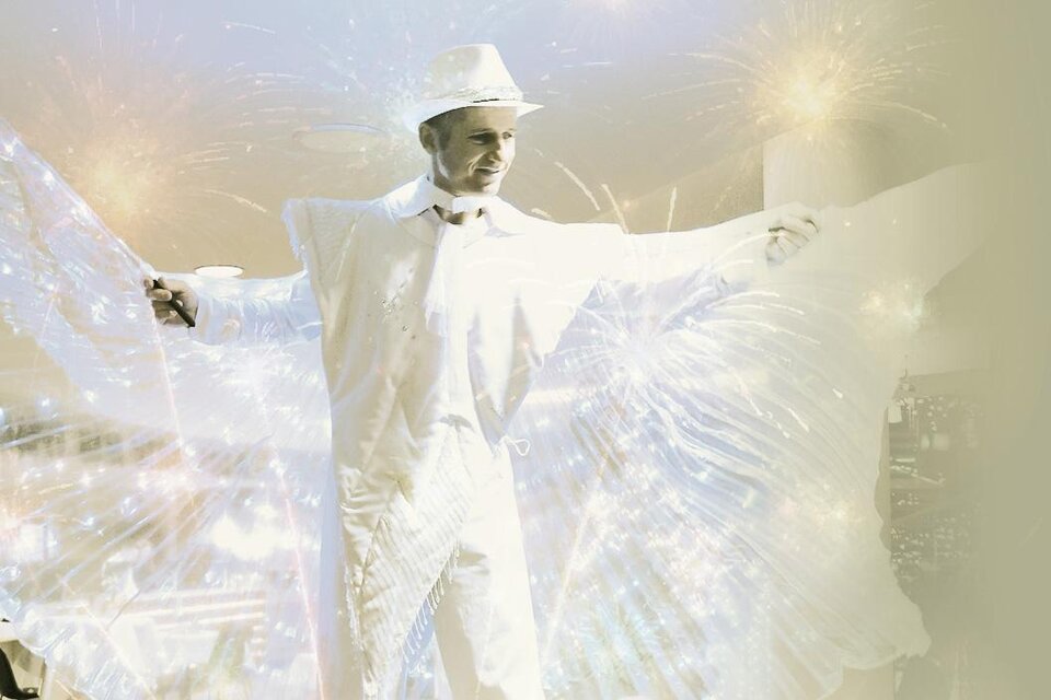 Ein Künstler in einem weißen Anzug zeigt eine beeindruckende Performance. Funken und Lichter schaffen eine festliche Atmosphäre. | © Das Sonnreich