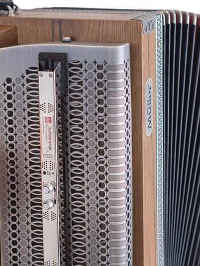 A musician holds an accordion. It is made of wood and has many keys. | © Pixabay