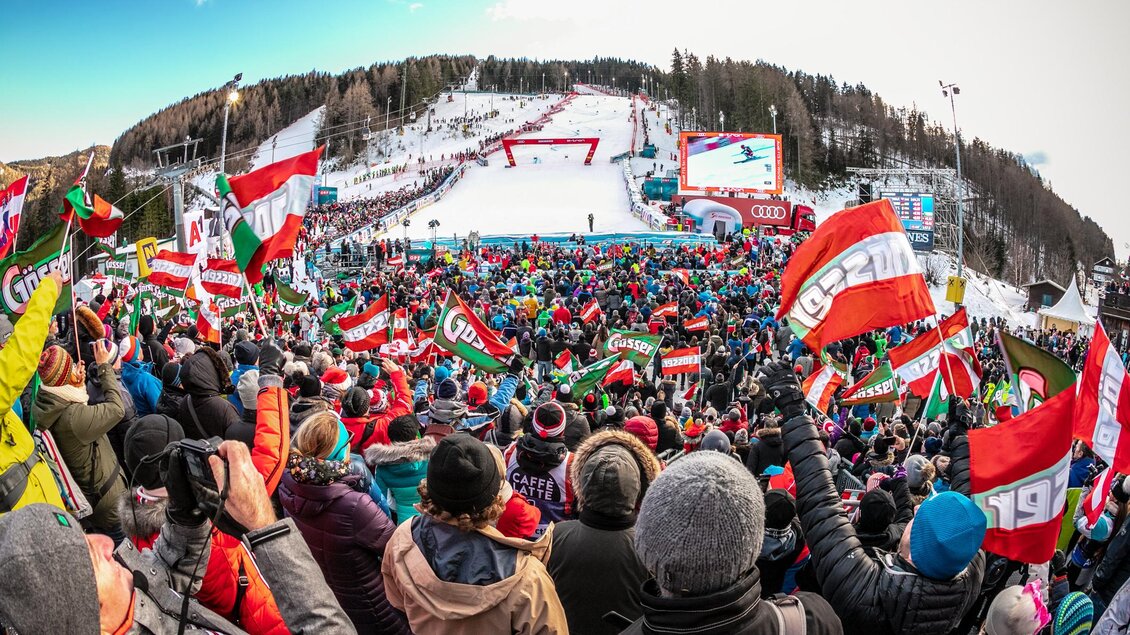 Eine große Menschenmenge jubelt auf einer Skisportveranstaltung. Viele Zuschauer halten Fahnen und feiern in einer festlichen Atmosphäre. | © Weltcup OK Semmering