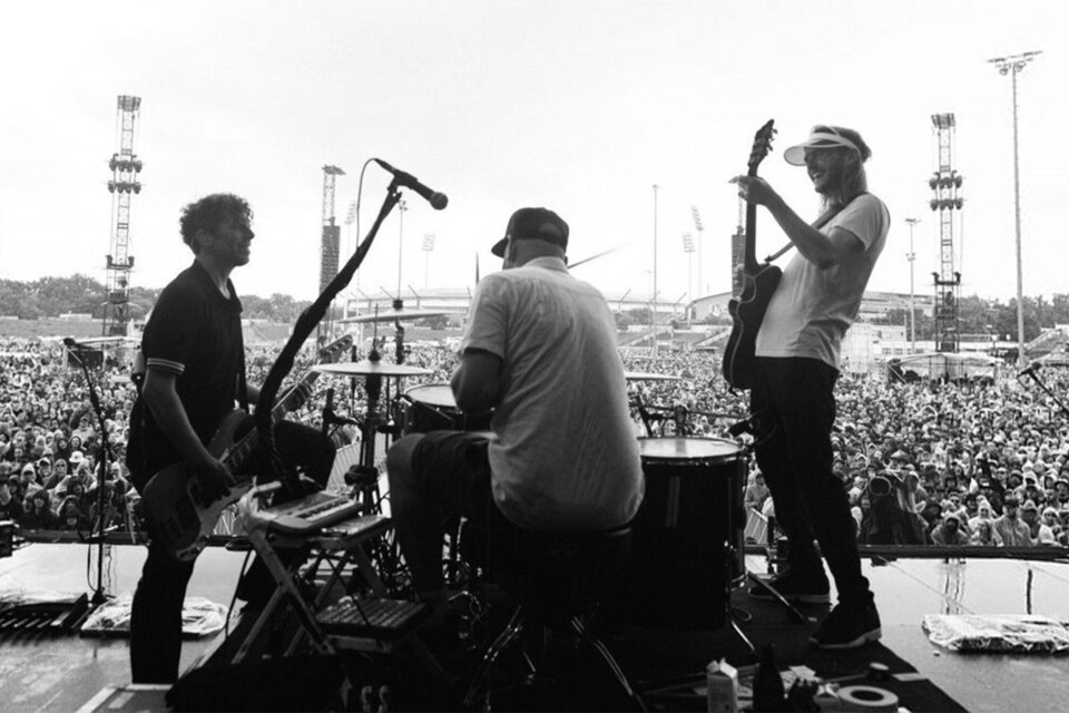 Eine Band spielt auf einer Bühne vor einem großen, begeisterten Publikum. Im Hintergrund sind weitere Bühnen und ein Riesenrad zu sehen. | © Ingo Pertramer