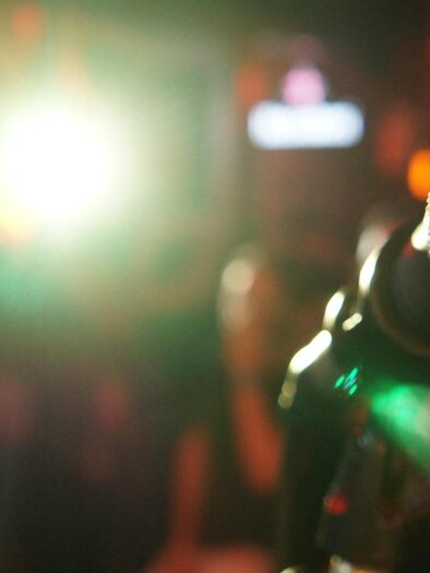 Microphone in the foreground with a blurred background. The scene is lit with colorful lights that create a vibrant atmosphere. | © Pixabay