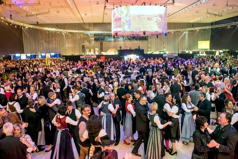 Eine große Menschenmenge tanzt in traditionellen Trachten auf einer Veranstaltung. Die Atmosphäre ist lebhaft und festlich, mit vielen Tänzern in bunten Outfits. | © Foto Fischer