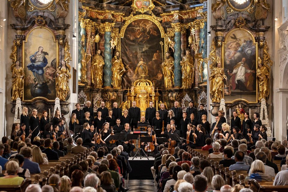 Ein Konzert in einer prächtigen Kirche mit vielen goldenen Verzierungen. Der Chor und das Orchester stehen auf der Bühne vor einem großen Publikum. | © Nikola Milatovic