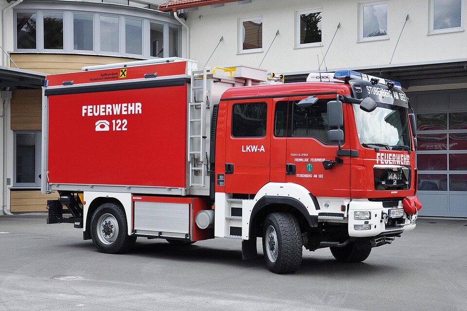 Ein rotes Feuerwehrfahrzeug steht vor einem Feuerwehrgebäude. Es hat einen großen Kastenaufbau und das Logo der Feuerwehr ist sichtbar. | © Freiwillige Feuerwehr Stubenberg_Oststeiermark