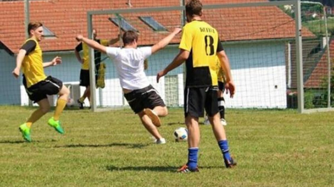 Zwei Teams spielen Fußball auf einem Rasenfeld. Ein Spieler fällt, während die anderen ihm zuschauen. | © SV Leitersdorf