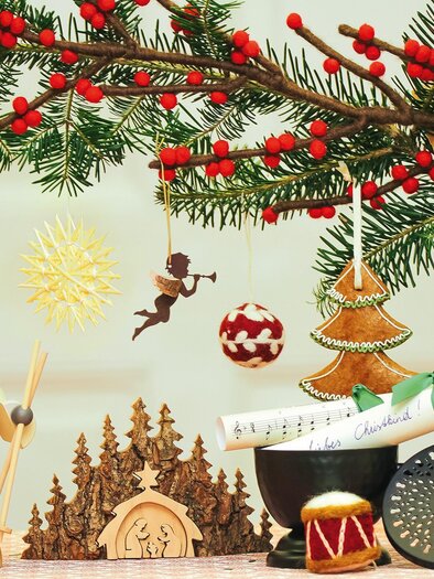 A festively decorated Christmas tree with colorful ornaments and branches. Various Christmas figures and decorations complement the festive atmosphere. | © vkstmk