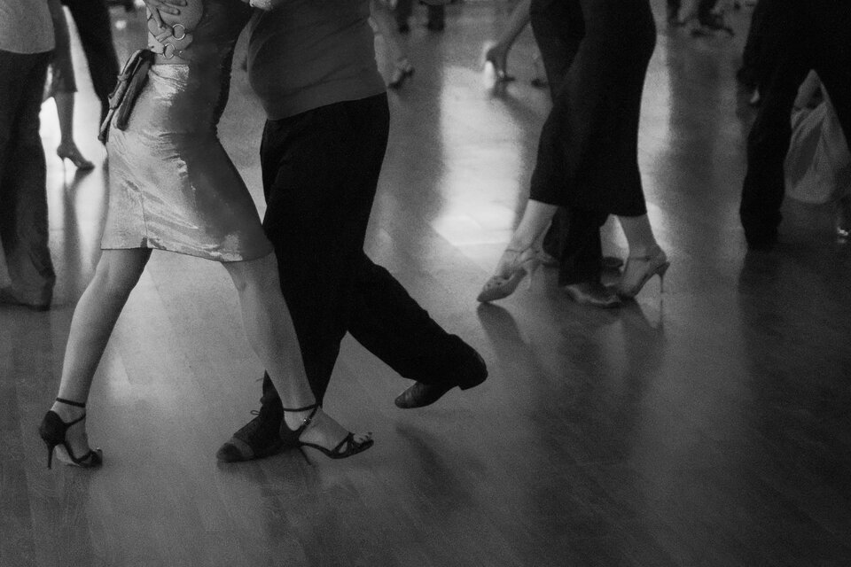 Tanzende Paare auf einer Tanzfläche, die in einer lebhaften Atmosphäre miteinander interagieren. Die Bewegung und Eleganz der Tänzer stehen im Fokus. | ©  @Christian Harb