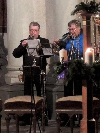 A small group of musicians is playing in a church. In the foreground are candles and chairs. | © Werner Pregetter