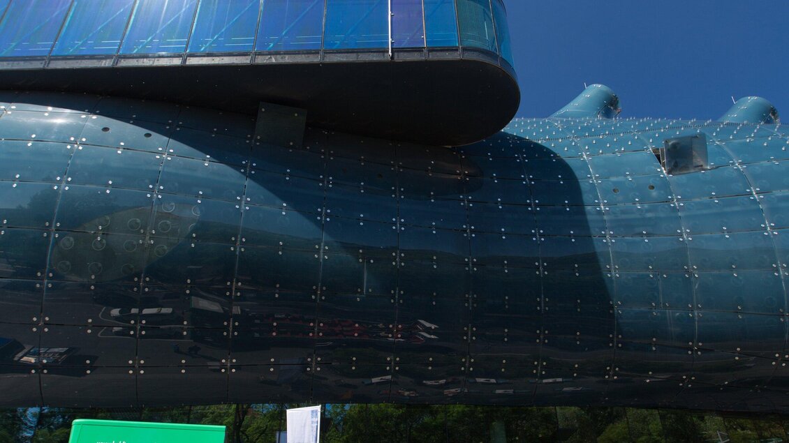 Eine moderne Architektur mit glänzender blauer Fassade und einzigartigem Design. Der Himmel ist klar und strahlend blau. | © Graz Tourismus - Harry Schiffer