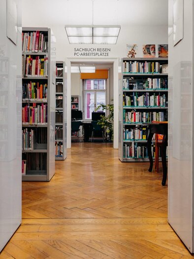 A cozy library with shelves full of books. In the background, reading nooks and plants are visible. | © © fotoCRafie – Christine Rechling
