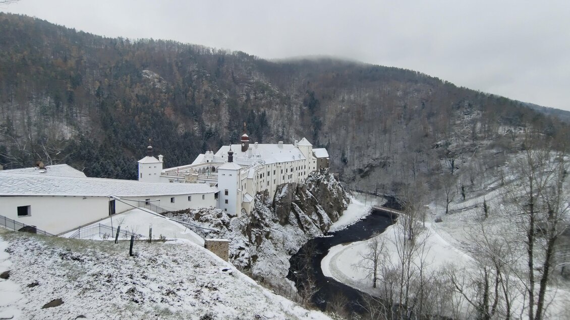 Eine verschneite Landschaft mit einem historischen Gebäude. Der Fluss windet sich durch die winterliche Umgebung. | © Edvin Gruber