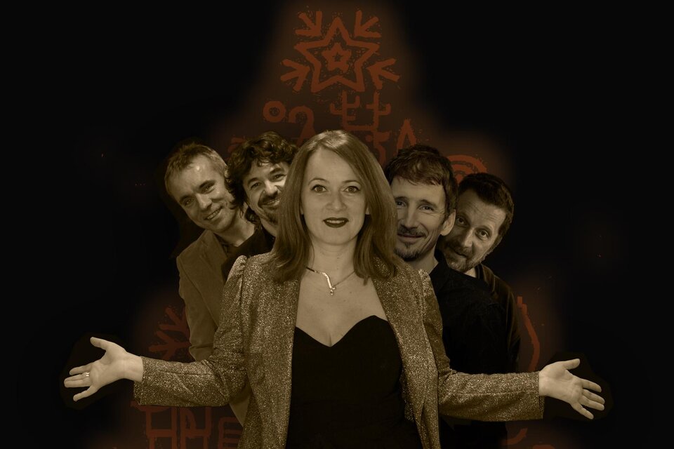 Eine Frau steht im Vordergrund und breitet die Arme aus, während vier Männer hinter ihr stehen. Der Hintergrund ist dunkel mit grafischen Mustern. | © Wosl