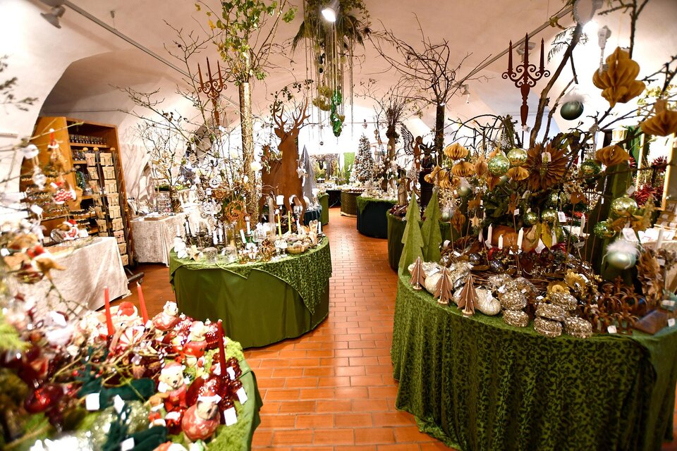 Ein wunderschöner Laden, der mit verschiedenen Dekorationen und Pflanzen geschmückt ist. Die Tische sind mit grünen Tüchern bedeckt und bieten eine Vielzahl von festlichen Artikeln an. | © Tourismusverband Thermen- & Vulkanland/Christian Thomaser