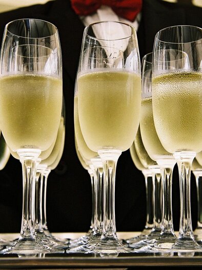 A tray with glasses of sparkling wine is ready to serve. The glasses are filled and gleam in the light. | © Tauroa GmbH
