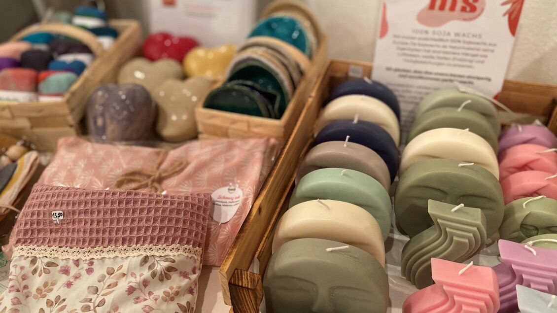 Bunte Seifen und Accessoires sind auf einem Tisch arrangiert. Die Produkte sind in Körben ausgestellt und zeigen eine Vielfalt an Farben und Formen. | © Hofladen Hauptmann