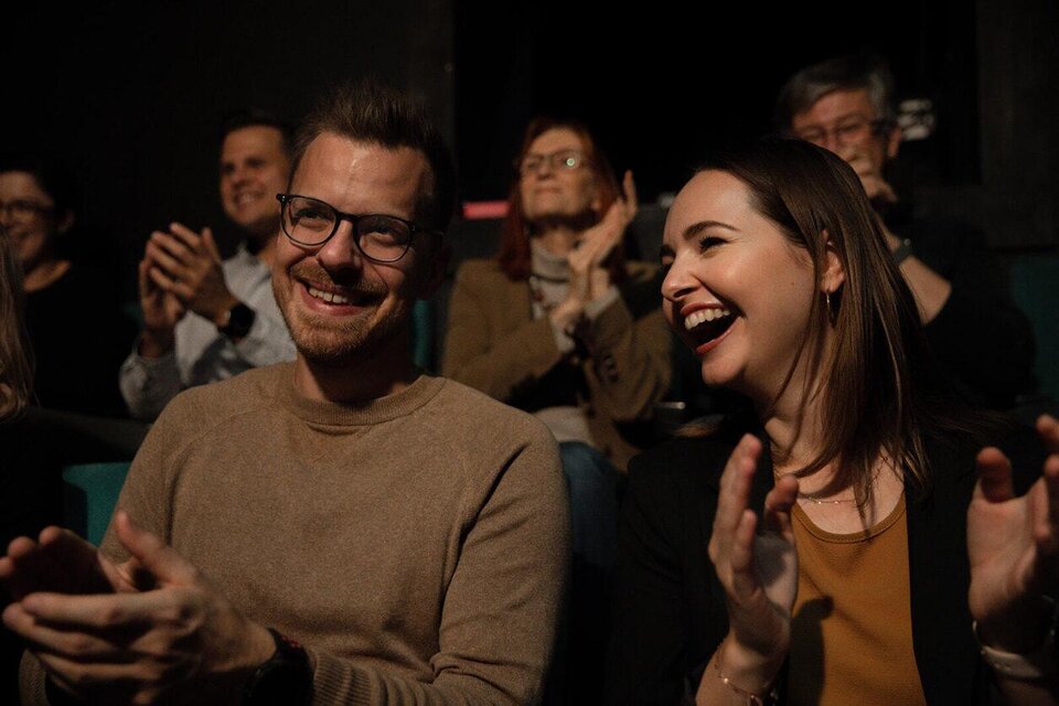 Ein lächelndes Paar sitzt im Publikum und applaudiert. Im Hintergrund sind weitere Zuschauer zu sehen, die ebenfalls Freude zeigen. | © TV Südsteiermark