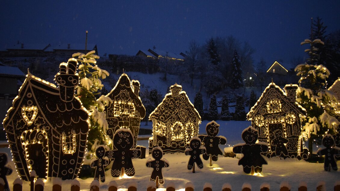 Eine festliche Winterlandschaft mit leuchtenden Lebkuchenhäusern und figürlichen Lebkuchenfiguren. Der Schnee sorgt für eine zauberhafte, winterliche Atmosphäre. | © Fam. Zwanzleitner
