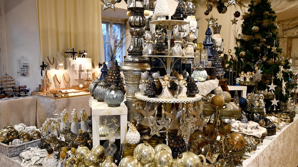 Ein festlicher Tisch mit Weihnachtsdekoration, geschmückt mit Glaskugeln, Sternen und Tannenzapfen. Im Hintergrund steht ein geschmückter Tannenbaum. | © Thermen- & Vulkanland