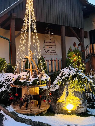 Ein festlich dekorierter Innenhof mit schneebedeckten Pflanzen. Lichterketten und Weihnachtsdekoration schaffen eine stimmungsvolle Atmosphäre. | © Wirtshaus Meißl