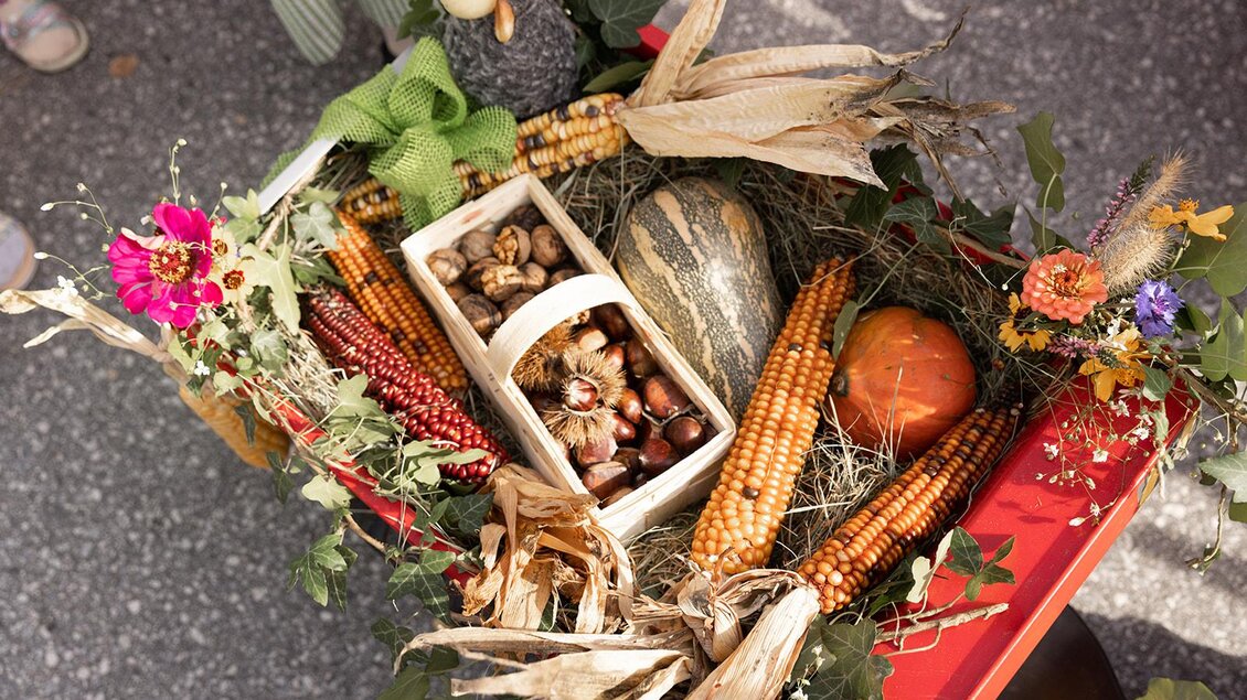 Ein rustikaler Erntetisch mit buntem Gemüse, Kastanien und buntem Mais. Der Tisch ist liebevoll mit Trockenblumen und Heu dekoriert. | © Achromatic Photography