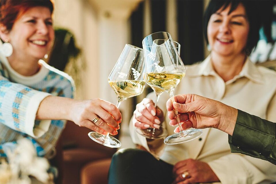 Drei Frauen stoßen mit Weingläsern an. Sie lächeln und genießen einen fröhlichen Moment zusammen. | © Thermen- & Vulkanland