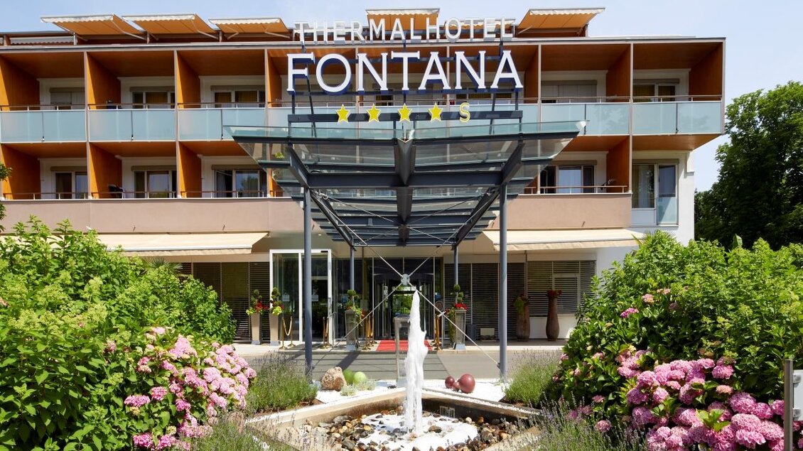 Ein modernes Hotel mit dem Namen "Thermalhotel Fontana". Vor dem Gebäude befindet sich ein schön gestalteter Eingang mit einem Springbrunnen und blühenden Pflanzen. | © Hotel Fontana