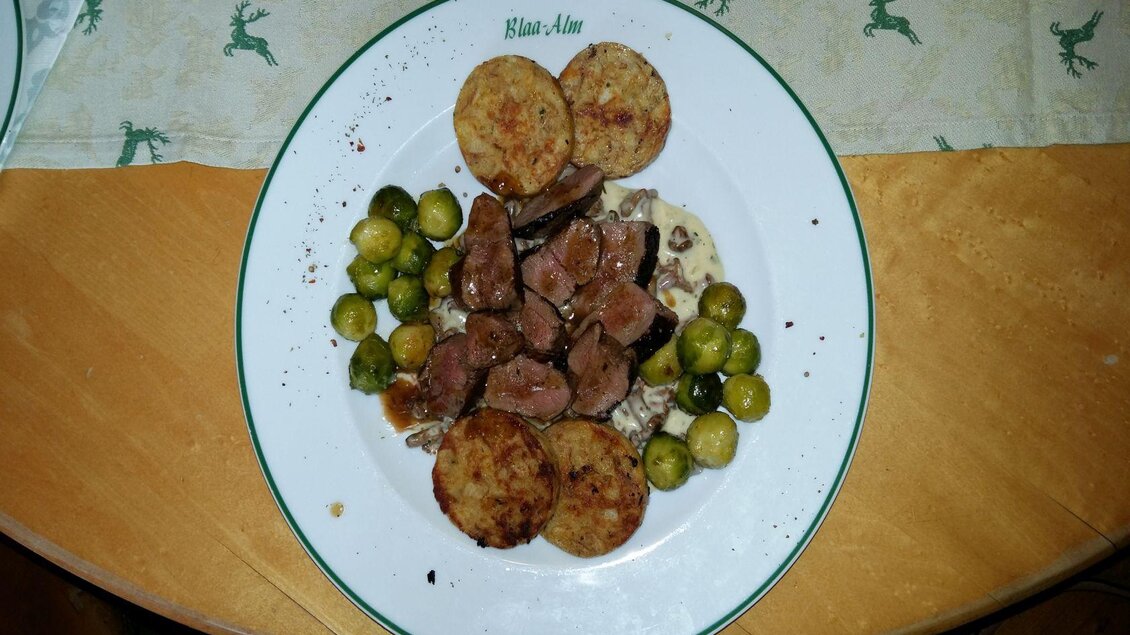 Ein Teller mit gebratenem Fleischstücken, Rösti und grünen Bohnen. Die Mahlzeit ist ansprechend angerichtet und sieht herzhaft aus. | © Petra Kirchschlager