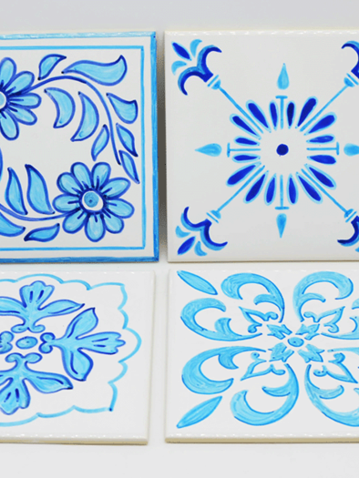 Four decorative tiles with blue patterns on a white background. Each design features different floral and geometric motifs. | ©  MuseumsCenter