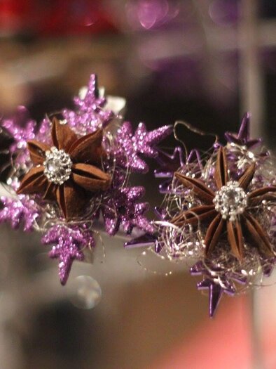 A decorative arrangement of purple sparkles and brown stars. The flowers appear playful and festive.