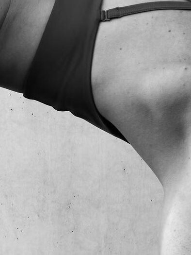 Eine Person macht eine sportliche Übung in einer halbseitigen Ansicht. Der Fokus liegt auf dem muskulösen Oberkörper und der Körperhaltung. | © we.move