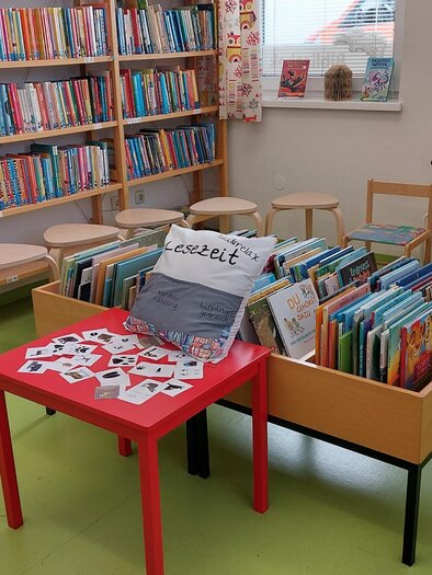 A pleasant room with shelves full of books and a table with various children's books. Chairs are ready for reading sessions or activities. | © Öffentliche Bibliothek der MG Stainach-Pürgg