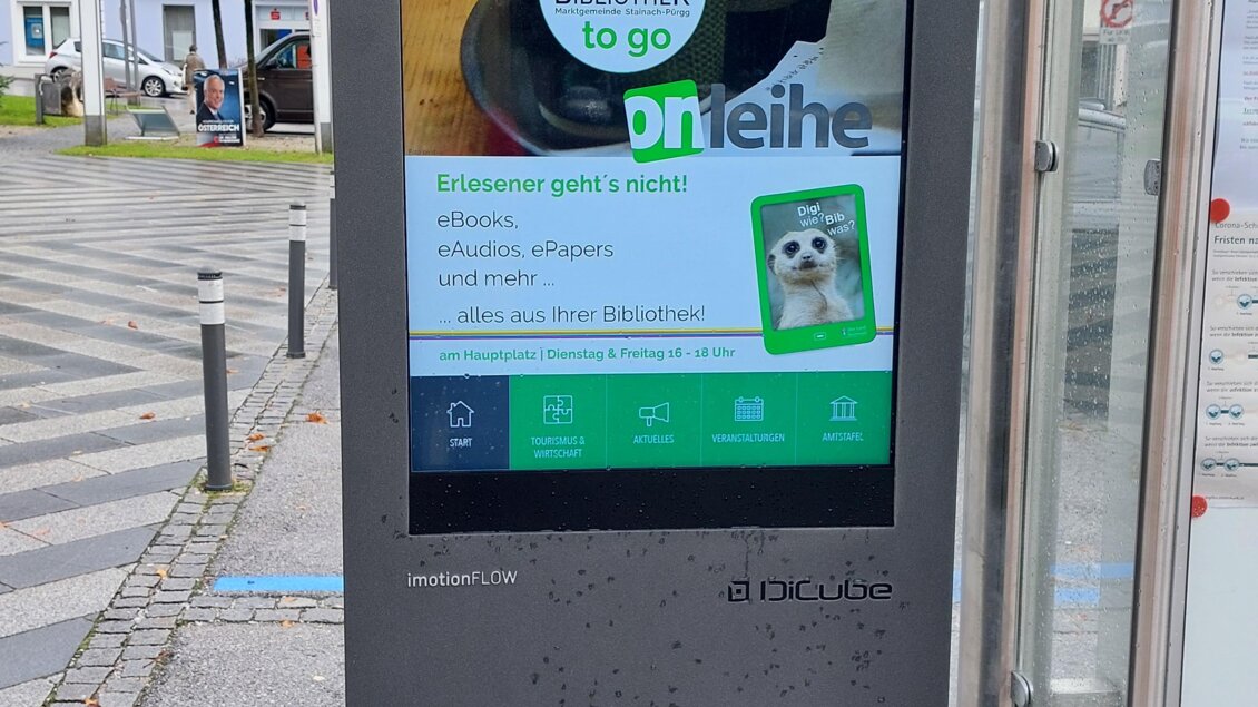 Ein Informationsstand mit digitalem Bildschirm an einer Haltestelle. Der Bildschirm zeigt Angebote für Kaffee und andere Snacks. | © ÖB der MG Stainach-Pürgg