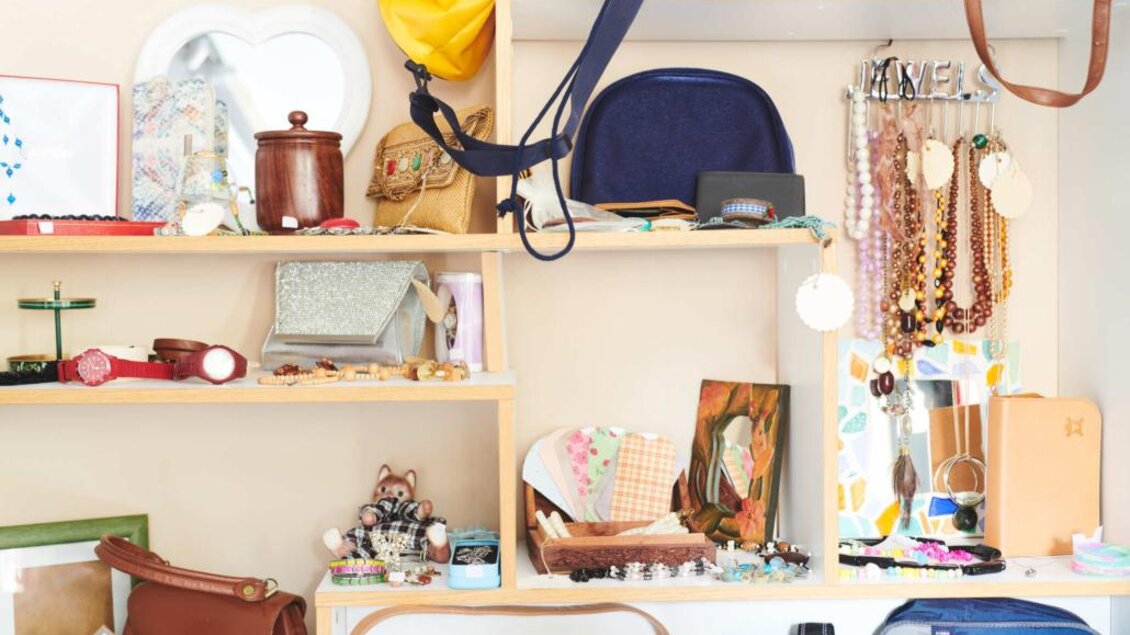 Eine bunte Auswahl an Accessoires und Taschen auf einem Regal. Diverse Schmuckstücke, Spiegel und kleine dekorative Objekte sind ebenfalls zu sehen. | © Verein ALH