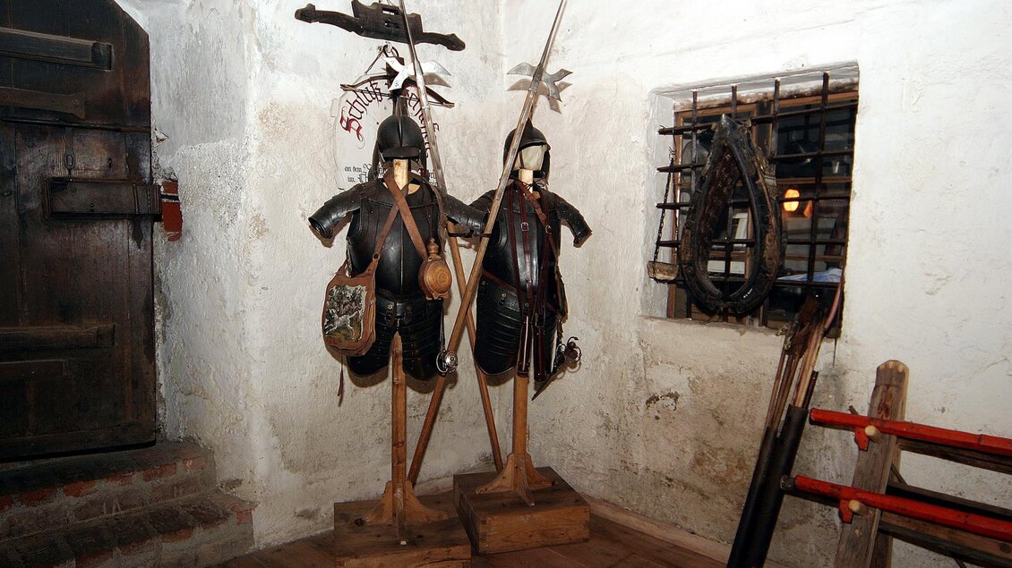 Zwei historische Rüstungen stehen in einem Raum. Der Raum hat eine rustikale Atmosphäre mit dicken Wänden und einem kleinen Fenster. | © Marktgemeinde Thörl