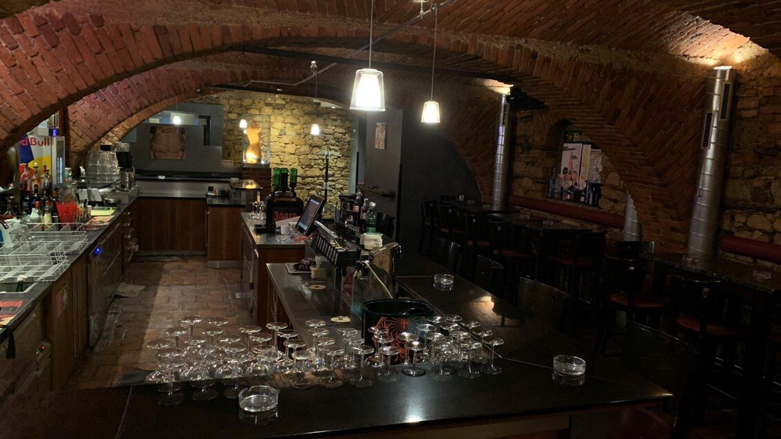 Eine gemütliche Bar mit einem rustikalen Ambiente und einem gewölbten Ziegelstein-Decke. Auf der Theke stehen Gläser bereit und die Einrichtung ist dunkel gehalten. | © Markus Nussbacher