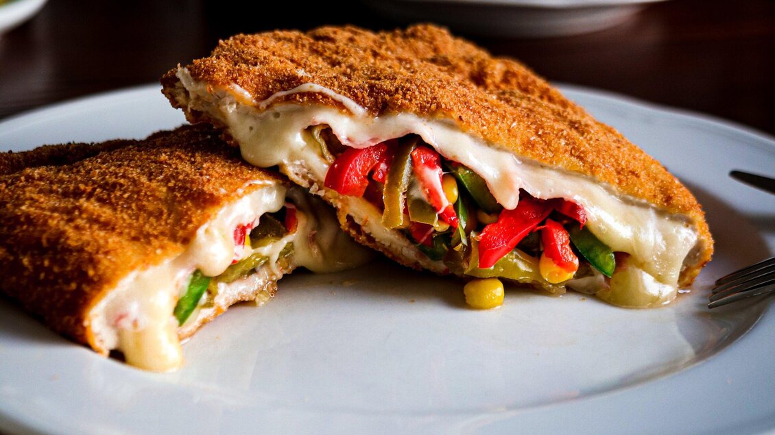 Ein Teller mit knusprigem, gefülltem Pfannengericht. Es enthält Käse und eine bunte Mischung aus Gemüse. | © 3 Goldene Kugeln