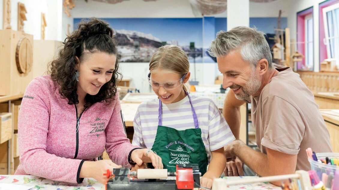 Eine Gruppe von drei Personen arbeitet zusammen an einem kreativen Projekt. Sie lächeln und scheinen viel Spaß bei der Aktivität zu haben. | © www.zloam.at