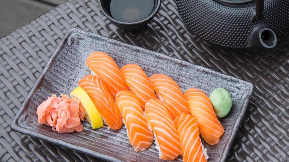 Acht Stück Lachs-Nigiri mit Wasabi, Ingwer und Sojaschale auf grauer Platte im Akakiko Graz | © Akakiko