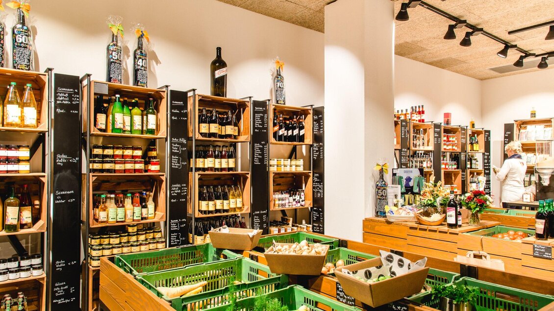 Ein gut sortierter Supermarkt mit Regalen voller Lebensmittel und Getränken. Im Vordergrund sind grüne Kisten für Obst und Gemüse zu sehen. | © Region Graz - Mias Photoart