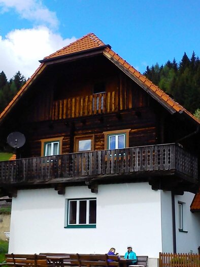 A charming old house in Allgäu style with a sloping roof and a balcony. Surrounded by lush forests and beautiful scenery. | © A. Steininger