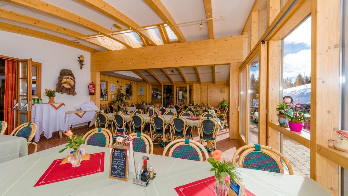 Ein gemütliches Restaurant mit Holzbalkendecke und großen Fenstern. Die Tische sind schön gedeckt und der Raum ist freundlich dekoriert. | © Almidylle Sabathy