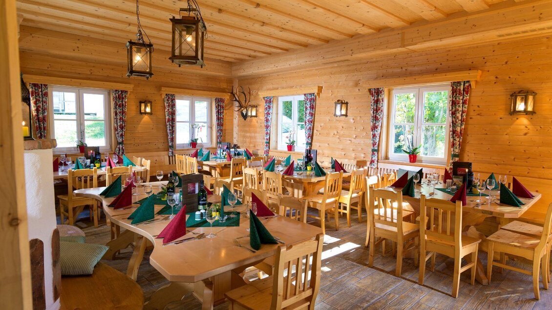 Ein gemütlicher Gastraum mit Holzmöbeln und dekorativen Tischgedecken. Die warmen Farben und das natürliche Licht schaffen eine einladende Atmosphäre. | © Gerhard Wolkersdorfer